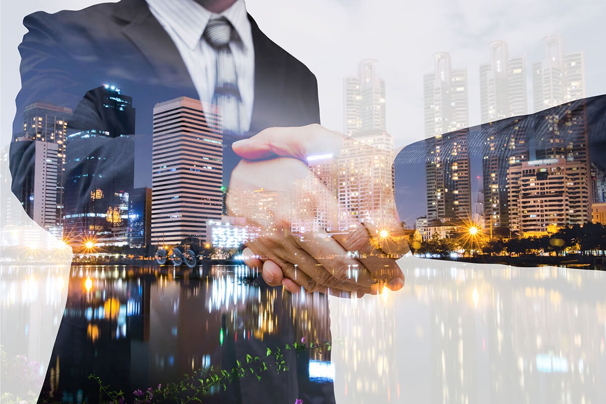 Business handshake with city skyline